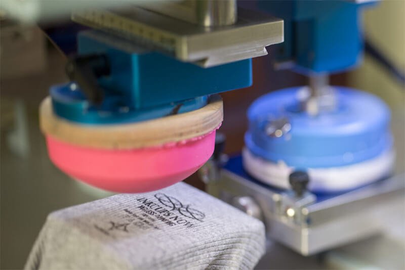 Pad printing a logo on elastic strap for swimwear